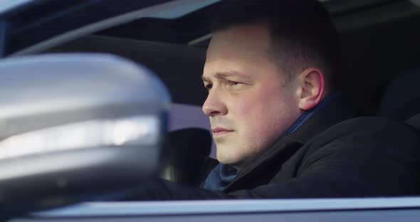 A Man Sitting In The Car Talking On A Mobile Phone