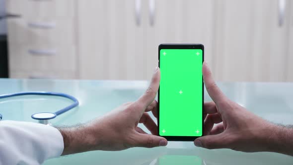 Close Up Shot of Male Hands Holding a Smartphone with Green Screen