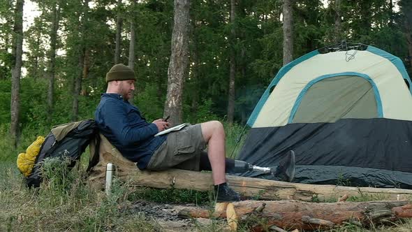 disabled man enjoys rest in forest after hike uses smartphone