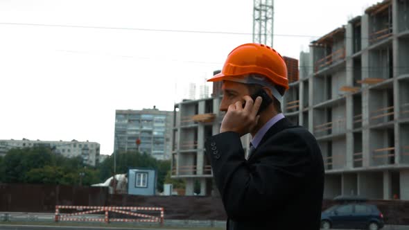 Builder in Helmet Talking on a Smart Phone.