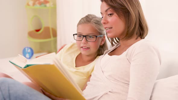 Happy Girl with Mother Reading Book at Home 47