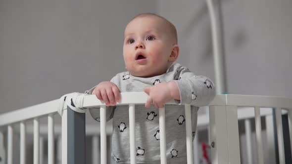 Baby Standing in a Crib at Home