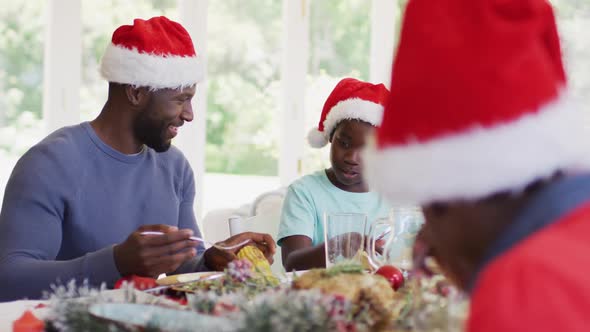 African american father serving food in plate of his son