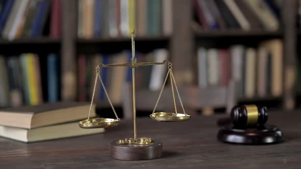 Gold Brass Balance Scale with Books and Gavel on Judge Table