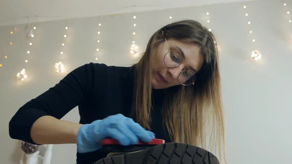 A Woman Cleans Shoes in Her Apartment