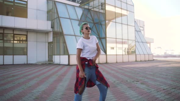 Attractive Young Woman in a Stylish Look and Green Hair Dancing Freely on Urban Background Slow