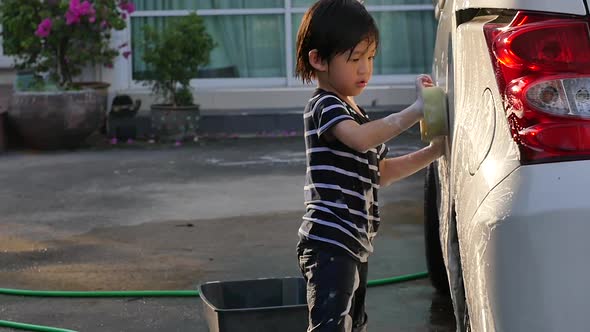 Asian Child Washing Car In The Garden On Summer Day