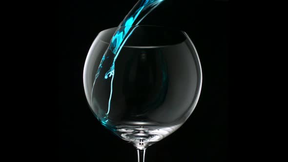 Pouring blue water into glass, Slow Motion