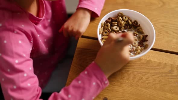 Top View Little Girl Enjoy Eating Cereal with Milk for Morning Breakfast with Appetite