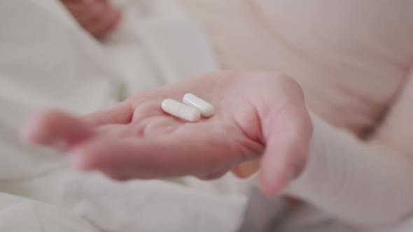 Close up of woman holding pills in her hand