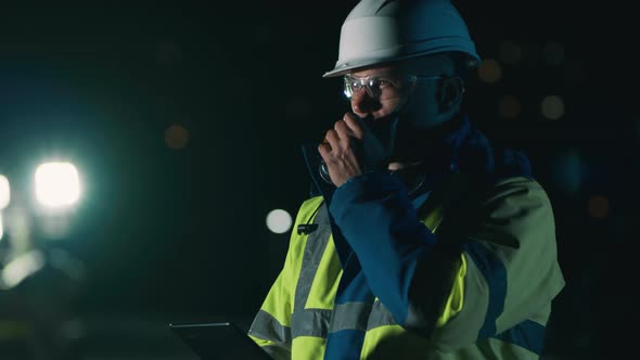 Male Worker Using Tablet and Talking on Radio