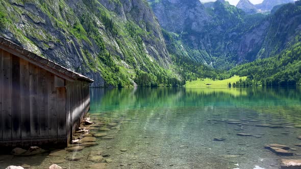 Tilt up shot of picturesque landscape with giant mountains and clear natural lake in Europe - Wooden
