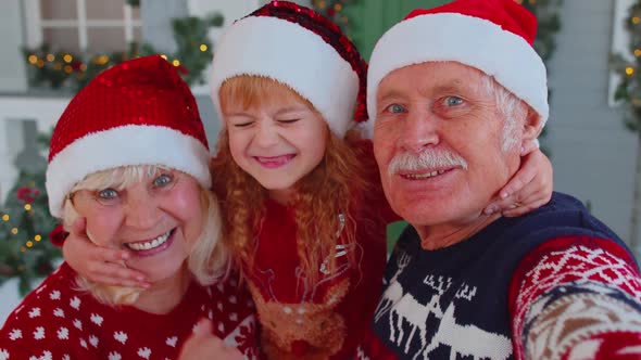 POV Shot of Senior Grandparents with Grandchild Girl Kid Taking Selfie on Mobile Phone on Christmas