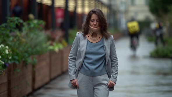 Adult Woman with Neck Ache Is Wearing Cervical Collar for Curing Osteochondrosis During Walk in City