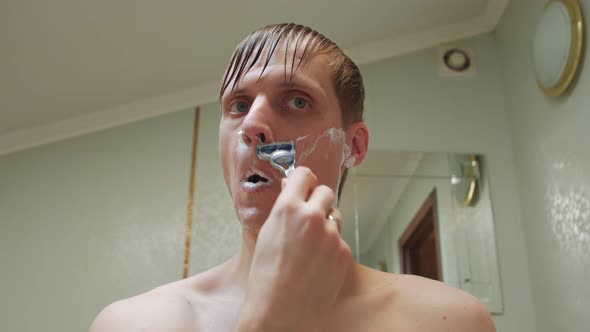 Man Shaving With A Razor