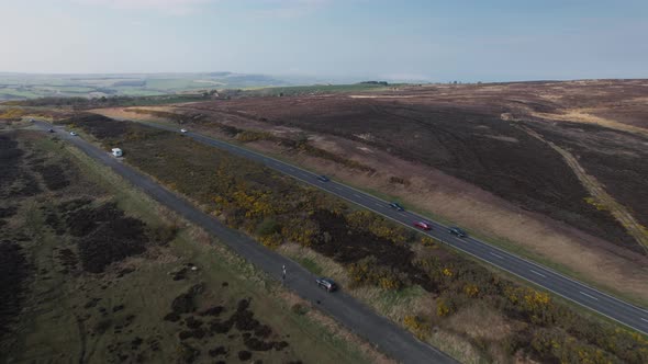 Aerial shot of empty street and grazing grass surround the street. Heather in bloom over the North Y