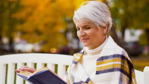 Happy Senior Woman Reading Book at Autumn Park 30