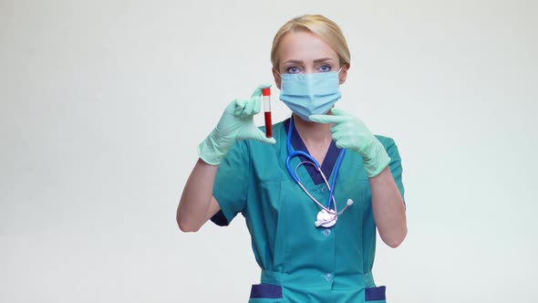 Medical Doctor Nurse Woman Wearing Protective Mask and Latex Gloves - Holding Blood Test Tube