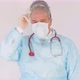 Doctor removing mask in a white coat personal protective equipment and protective mask  - VideoHive Item for Sale