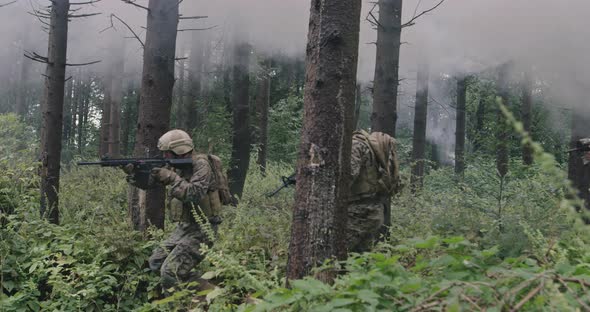 Soldiers in the Smoke Moving in Battle Operation Through Dense Forest