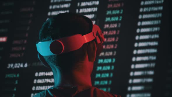 Trader in a Virtual Reality Helmet Looks at Cryptocurrency Charts