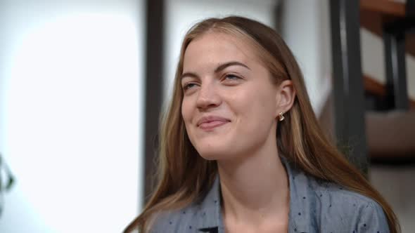 Closeup Portrait of Laughing Teenage Caucasian Girl Looking Away Dreaming Indoors