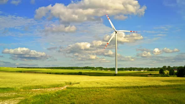 One white wind turbine on field, aerial view alt