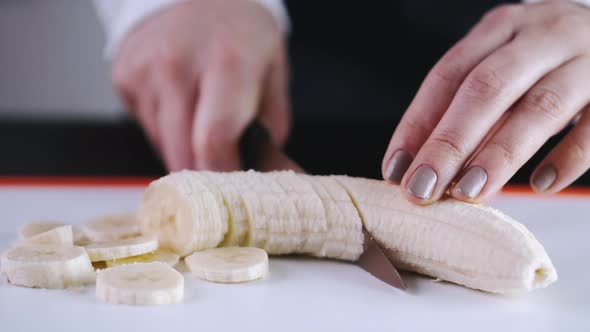 The Chef Is Slicing a Banana on a Cutting Board