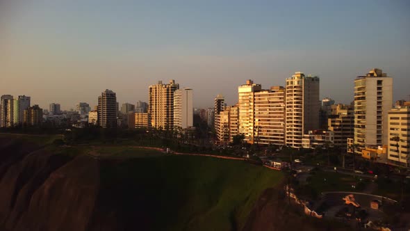 AERIAL - Sunrise and luxury buildings, Miraflores, Lima, Peru, wide shot forward