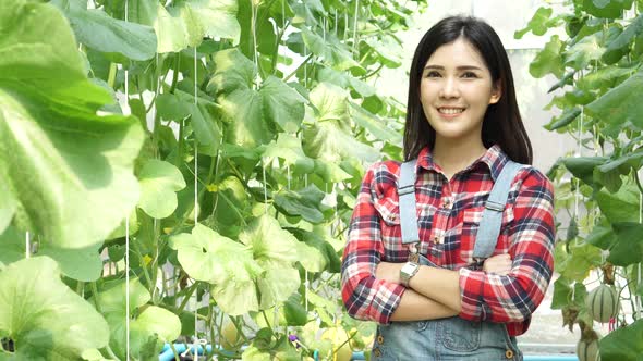 Young Asian Female Farmer Having Arms Crossed with Happy Smile Inside Farm Agriculture Garden