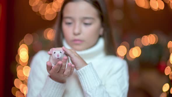 Cute girl holds and strokes a white rat