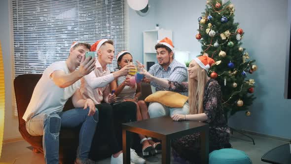 Cheerful Friends in Santa Hats Making Video Call By Smartphone on Christmas Party