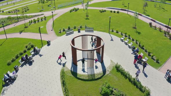 Children Play with Round Swings in Nice Park Aerial View