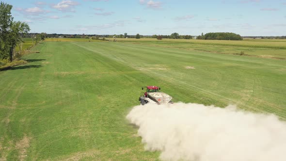 farm tractor spreading white powder medium height angled