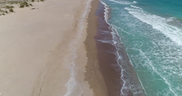 Aerial footage of drone flying over beautiful empty beach,