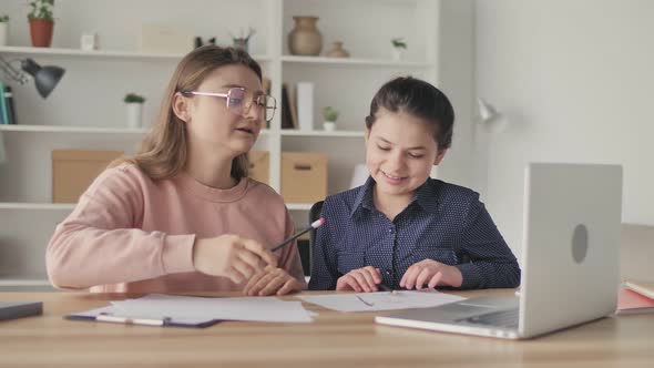 Young Womanmentor Helping Teenage Girl Study Do Homework Using Laptop