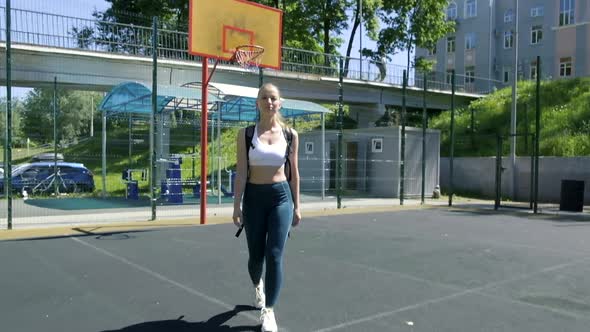 Young Athletic Blond Woman with Ponytail in Sportswear Walking at Sports Ground