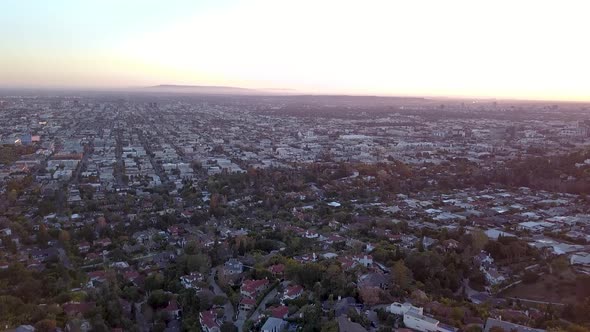 Vast Los Angeles neighborhoods seen from the air above during sunset.