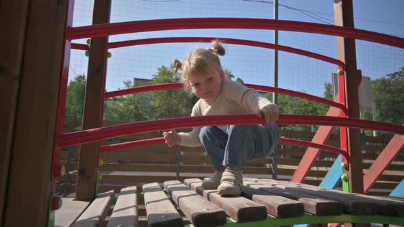 Little Blond Girl Sneaks at Children's Playground