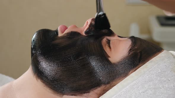 Preparation for Cosmetic Procedure in Beauty Clinic. Cosmetologist Applies Carbon Compound on Skin