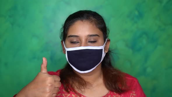 Hopeful Asian Indian girl wears protective mask for prevention of Covid-19 coronavirus at home due t