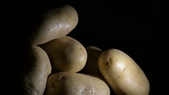 Vegetables Potatoes Gyrating on Black Background. Solanum Tuberosum