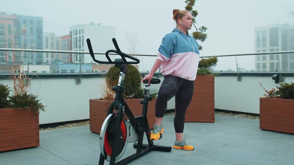 Woman Performs Aerobic Endurance Training Workout Cardio Routine on the Simulators Cycle Training