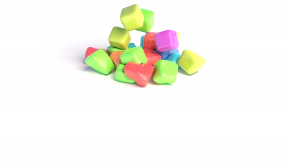 Rubber Colored Cubes Fall Onto a White Surface