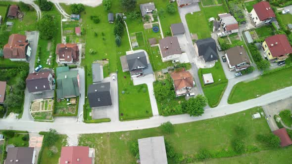 Flying over alleys of family houses settlement between green lawns. Aerial 4k view.