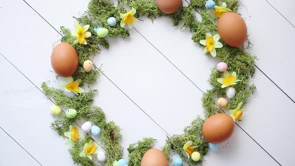 Colorful Decorative Easter Eggs Wreath on White Wooden Table Background