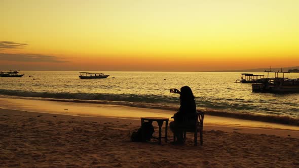 One woman tanning on exotic lagoon beach vacation by blue ocean with white sandy background of the M