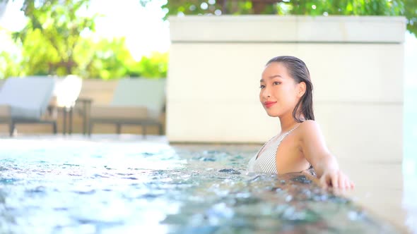 Young asian woman enjoy around outdoor swimming pool for leisure