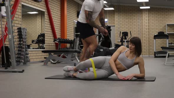 Sportswoman Training with Personal Instructor in Gym