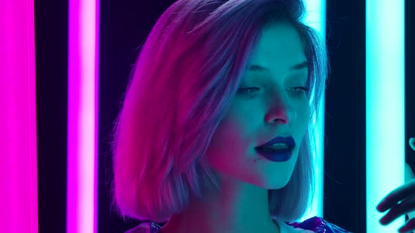 Portrait of a Young Stylish Sexual Blonde with Pink Short Hair Poses Against a Dark Studio
